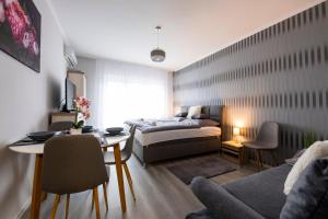 salon z łóżkiem i stołem w obiekcie Csipke Apartman w mieście Makó