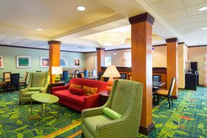 a hotel lobby with a red couch and chairs at Fairfield Inn & Suites Lock Haven in Lock Haven