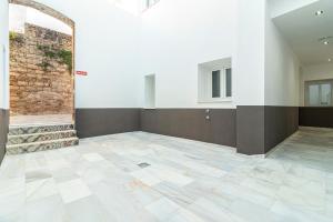 Habitación vacía con pared de ladrillo y suelo de baldosa. en Top & Chic Albarizuela Suites - Apartamentos Jerez, en Jerez de la Frontera