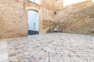 een kamer met een tegelvloer en een bakstenen muur bij Top & Chic Albarizuela Suites - Apartamentos Jerez in Jerez de la Frontera