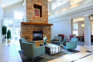 a lobby with chairs and a fireplace in a building at Residence Inn Lafayette Airport in Lafayette