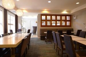 a dining room with wooden tables and chairs at Residence Inn Lafayette Airport in Lafayette