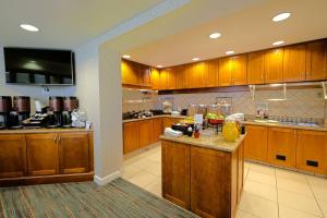 a large kitchen with wooden cabinets and a counter at Residence Inn Lafayette Airport in Lafayette