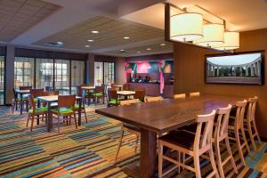 Fairfield Inn & Suites by Marriott Atlanta Buford/Mall of Georgia في بوفورد: غرفة طعام مع طاولة وكراسي خشبية كبيرة