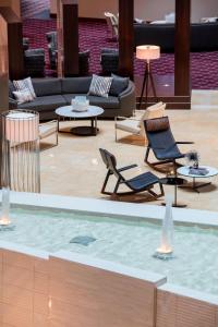 a living room with a pool with chairs and a couch at Renaissance Dallas Richardson Hotel in Richardson