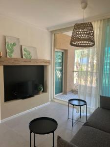 uma sala de estar com um sofá e uma televisão em lasuita-exclusive suites ceserea-sunset suite em Caesarea