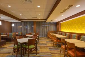 a dining room with tables and chairs and a yellow wall at Fairfield Inn & Suites By Marriott Fort Lauderdale Downtown/Las Olas in Fort Lauderdale