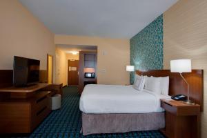 a hotel room with a large bed and a flat screen tv at Fairfield Inn & Suites By Marriott Fort Lauderdale Downtown/Las Olas in Fort Lauderdale