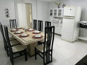 a kitchen with a table and chairs and a white refrigerator at Apto da Dê - Centro de Venda Nova do Imigrante ES in Venda Nova do Imigrante