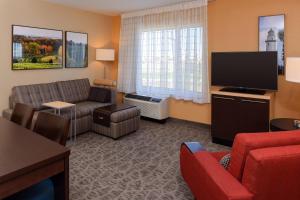 a living room with a couch and a flat screen tv at TownePlace by Marriott Suites Detroit Auburn Hills in Auburn Hills