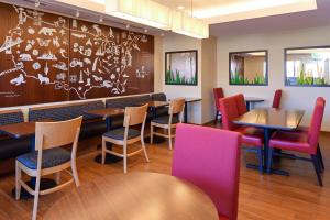un restaurante con mesas, sillas y una pared en TownePlace by Marriott Suites Detroit Auburn Hills, en Auburn Hills