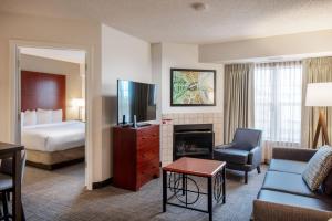 a hotel room with a bed and a living room at Residence Inn by Marriott Little Rock in Little Rock
