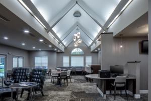 a waiting room with chairs and tables and a window at Residence Inn by Marriott Little Rock in Little Rock