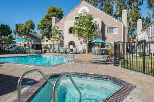 a swimming pool with a patio and a house at Residence Inn by Marriott Oxnard River Ridge in Oxnard