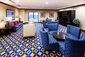 hol z niebieskimi krzesłami i telewizorem w obiekcie Houston Marriott Energy Corridor w mieście Houston