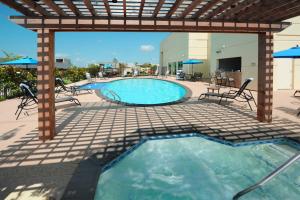 a swimming pool with chairs and a pergola at Houston Marriott Energy Corridor in Houston