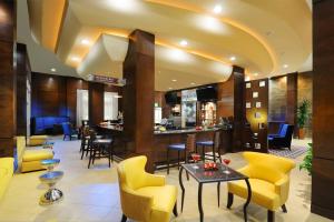 a lobby of a hotel with yellow chairs and a bar at Houston Marriott Energy Corridor in Houston