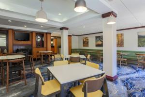 jadalnia ze stołami i krzesłami oraz telewizorem w obiekcie Fairfield Inn & Suites by Marriott Mahwah w mieście Mahwah