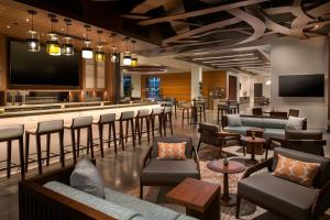 a bar in a hotel lobby with chairs and a tv at Element Reno Experience District in Reno