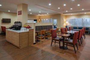 um restaurante com mesas e cadeiras e uma cozinha em TownePlace by Marriott Suites Clarksville em Clarksville