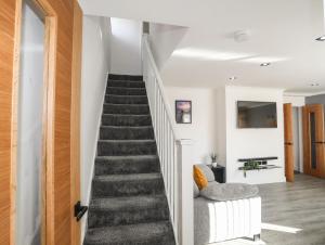 a staircase in a home with white walls and wooden floors at Alaw View in Amlwch