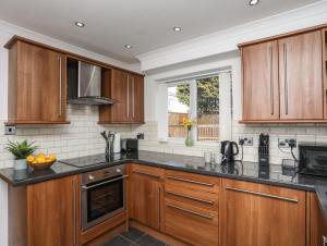 a kitchen with wooden cabinets and black counter tops at Alaw View in Amlwch