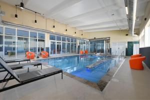 uma grande piscina com cadeiras laranja num edifício em Aloft Lubbock em Lubbock