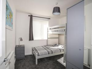 a bedroom with a bunk bed and a window at Alaw View in Amlwch
