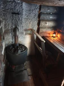 a room with a stove and a chair in a building at Log Cabin - Lord of Sormuset in Inari