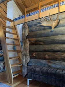 Habitación con escalera y pared con cabaña de madera. en Log Cabin - Lord of Sormuset en Inari