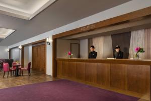 two people standing at a reception desk in a hotel lobby at Courtyard by Marriott Hakuba in Hakuba