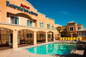 a hotel with a swimming pool in front of a building at Fairfield Inn & Suites Modesto in Modesto