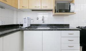 a white kitchen with a sink and a microwave at Tabas Incrível cobertura em Copacabana CP0012 in Rio de Janeiro