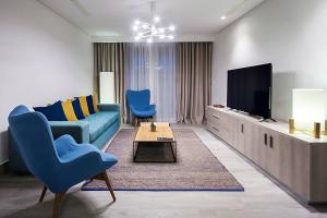 sala de estar con sofá azul y TV en Sousse Pearl Marriott Resort & Spa en Sousse