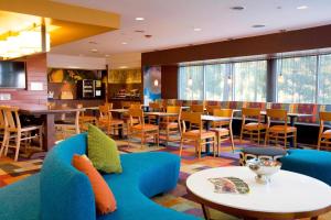 a hotel lobby with a blue couch and tables and chairs at Fairfield Inn & Suites by Marriott Chesapeake Suffolk in Chesapeake