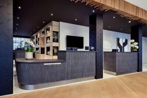 a lobby with a bar with a tv in it at AC Hotel by Marriott Strasbourg in Strasbourg