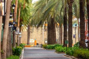 een loopbrug met palmbomen voor een gebouw bij Renaissance Wind Creek Curacao Resort in Willemstad