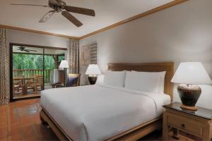 - une chambre avec un grand lit blanc et un ventilateur de plafond dans l'établissement Marriott's Phuket Beach Club, à Mai Khao Beach