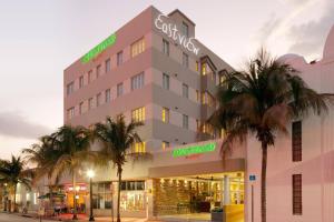 a hotel with palm trees in front of it at Courtyard Miami Beach South Beach in Miami Beach