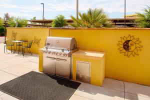 a yellow wall with a stove and a table at TownePlace Suites by Marriott Phoenix Goodyear in Goodyear