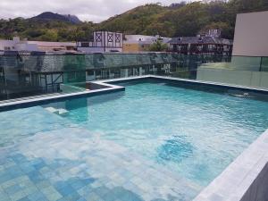 ein großer Pool auf einem Gebäude in der Unterkunft Apto Itaipava, piscina borda infinita, montanha in Itaipava