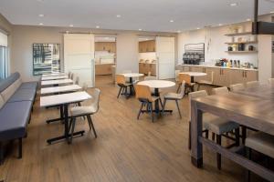 a restaurant with tables and chairs and a kitchen at Residence Inn by Marriott Modesto North in Modesto