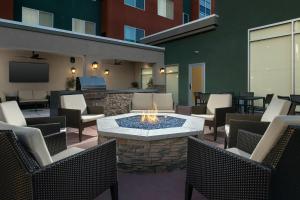 eine Terrasse mit einer Feuerstelle und Stühlen sowie einem TV in der Unterkunft Residence Inn by Marriott Modesto North in Modesto