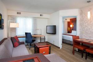 a hotel room with a couch and a bed at Residence Inn Rockford in Rockford