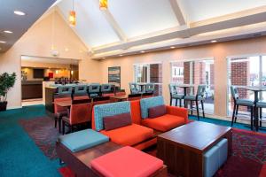 a lobby with a waiting area with tables and chairs at Residence Inn Rockford in Rockford