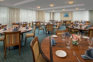a dining room with tables and chairs with flowers on them at Courtyard by Marriott Ocean City Oceanfront in Ocean City