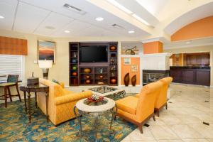 a living room with orange furniture and a tv at Residence Inn Spokane East Valley in Spokane Valley