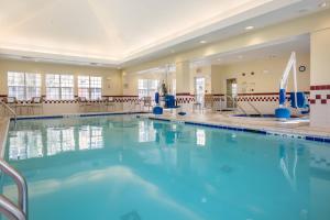 una piscina con agua azul en una habitación grande con sillas en Residence Inn Spokane East Valley en Spokane Valley
