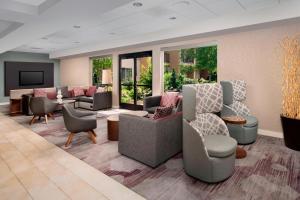 una sala de espera con sofás, mesas y ventanas en Courtyard by Marriott Portland Hillsboro, en Hillsboro
