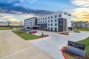 a building with a sign in front of a parking lot at Courtyard by Marriott Longview North in Longview